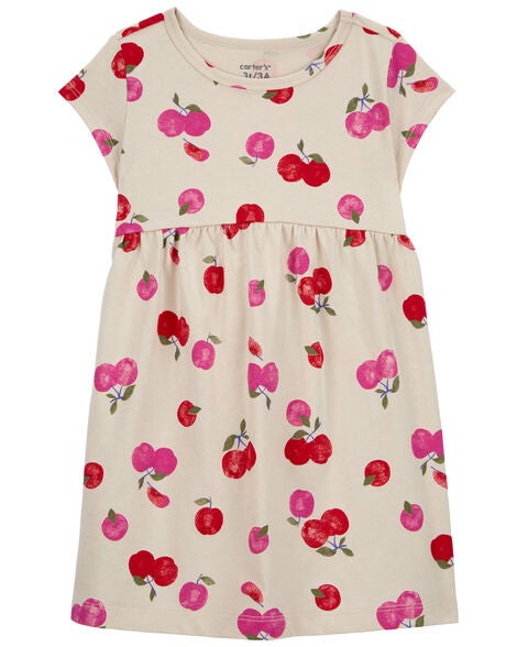 A cream-colored toddler dress with red and pink cherries on it